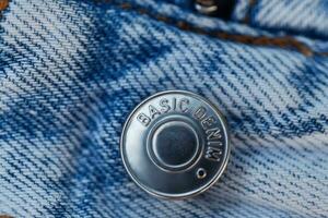 modern blå jeans med en metall knapp grundläggande denim, närbild. design och mode begrepp foto