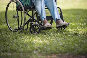 närbild ensam äldre kvinna sitter på rullstol i trädgården foto