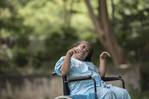 äldre kvinna som sitter på rullstol med Alzheimers sjukdom foto
