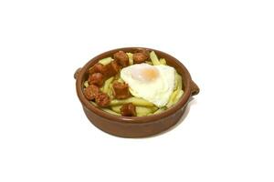 chistorra med friterad potatisar och friterad ägg, eras i en lera skål .chistorra, är en typ av korv av navarre ursprung tillverkad med färsk mald fläsk.isolerad i en vit bakgrund. spanska mat begrepp. foto