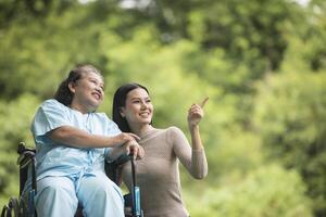 barnbarn pratar med sin mormor som sitter på rullstol foto