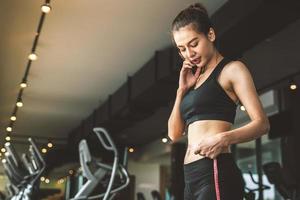 sport glad smal kvinna med midjebandlinje i fitness gym foto
