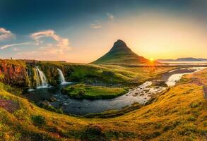 soluppgång över vulkanisk Kirkjufell berg med vattenfall strömmande i sommar på island foto