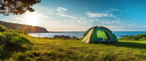 camping tält och camping Utrustning på grön gräs med hav se bakgrund ai genererad foto