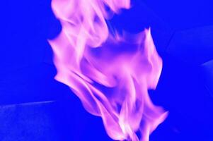 lila lågor, abstrakt virvlar av lila rök på en blå bakgrund. foto