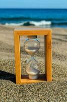 ett timglas på de strand med blå sand foto