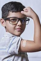 porträtt av Lycklig friska ung unge som visar bandage plåster på ärm axel efter få vaccination foto