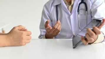 läkare i labrock och stetoskop använder en tablett. foto