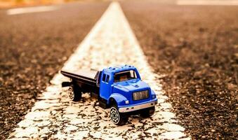 en leksak lastbil är körning ner en väg foto