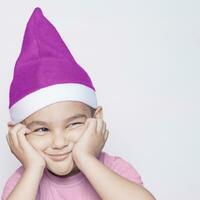 en liten unge framställning rolig irriterad ansikte. irriterad jul pojke i santa hatt foto