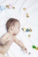 bebis pojke spelar med jul bollar och leksaker foto