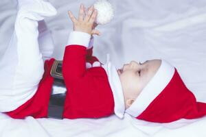 liten tomten. 6-9 månader gammal bebis pojke i santa claus kostym. glad jul foto