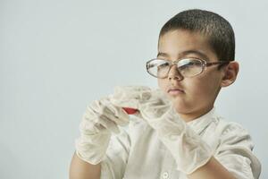 en unge i glasögon och handskar spelar med plastin foto