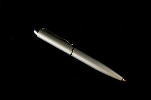 en silver- penna på en svart bakgrund foto