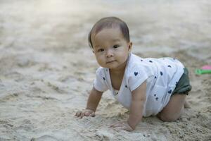 asiatisk litet barn bebis thai flicka spelar med sand foto