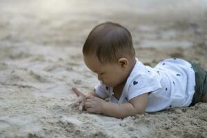 asiatisk litet barn bebis thai flicka spelar med sand foto