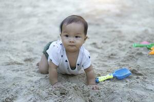 asiatisk litet barn bebis thai flicka spelar med sand foto