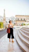 kvinna turist med stad Karta förbi de helgon oronzo staty i ostuni, Italien foto