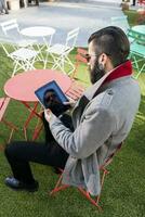 ung hipster konsulterar hans bärbar dator Sammanträde på bar foto