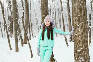 vacker ung flicka gå i vinter skog foto