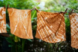 färgade batik trasa hängande i de utomhus- trädgård. foto