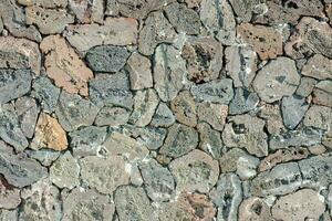 en sten vägg med många annorlunda typer av stenar foto