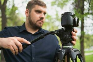 videographer skjuter video i en grön parkera. foto