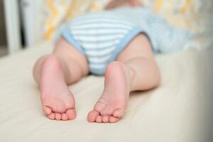 ben av en sovande bebis i de spjälsäng. barnets fot. foto