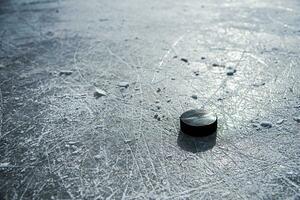 svart hockey puck lögner på is på stadion foto