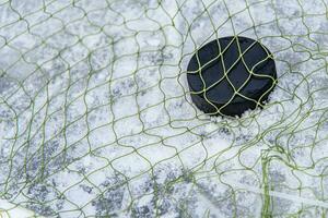 hockey puck i de mål netto närbild foto