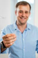 en leende tandläkare läkare innehar transparent inriktare i hans händer foto