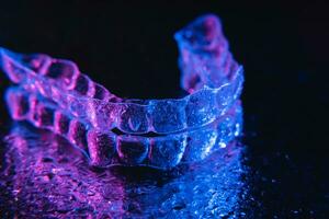 transparent aligners, tand hållare lögn på en spegel med vatten droppar på en svart bakgrund foto