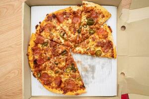 stänga upp pizza från leverans service i papper låda med ett led ljus från de sida ram. foto