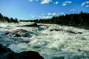 en flod med fors och träd i de bakgrund foto