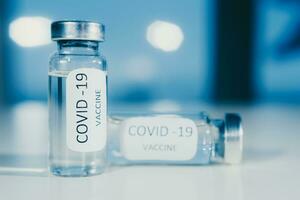vaccin mot coronavirus covid-19 i ett ampull på en blå bakgrund närbild. foto
