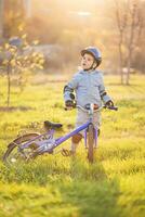 söt barn är körning en cykel på en solig dag på solnedgång foto