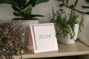 kalender 2024 och hus växter på en hylla foto