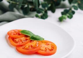 skivad röd tomater och basilika löv foto