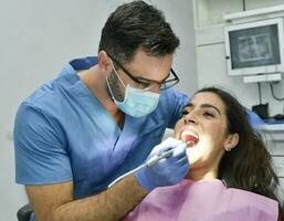 ai genererad ung man tandläkare utför oral behandling på en ung och skön patient foto