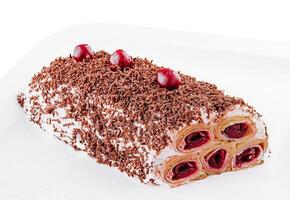 kaka från rullad pannkakor med grädde, körsbär och riven choklad på tallrik foto