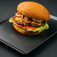 burger med svamp och kotlett på svart bricka foto