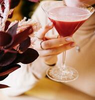 ung kvinna dryck röd cocktail med jordgubb foto