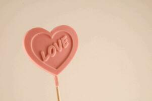 en rosa hjärta formad klubba med de ord kärlek skriven på den foto