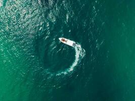 antenn se av hastighet båt i de aqua hav framställning en cirkel, Drönare se foto