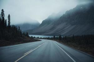 mystisk road trip med steniga berg i dimmigt på dyster i Banff National Park foto