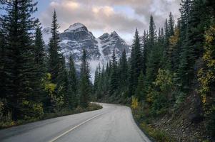 motorväg med steniga berg i tallskog vid moränsjön i banff nationalpark foto