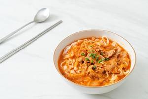 koreanska udon ramen nudlar med fläsk i kimchi soppa foto