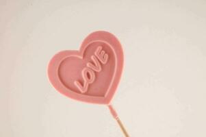 en rosa hjärta formad klubba med de ord kärlek skriven på den foto