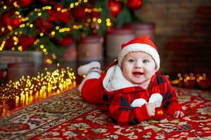 liten sex månad gammal bebis klädd som santa claus. bakgrund för jul kort. de barn utseende ner på de plats för inskrift. foto