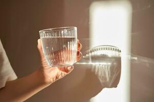 en glas av rena dricka vatten i de morgon- Sol. foto
